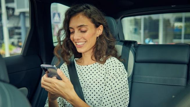 Woman looking at phone inside car