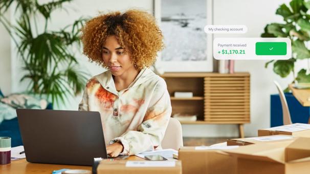 Woman behind a computer with a popup overlay of funds that have been paid out