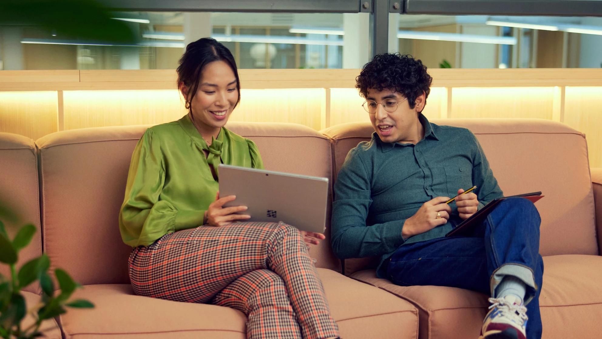Two people on a sofa viewing a tablet