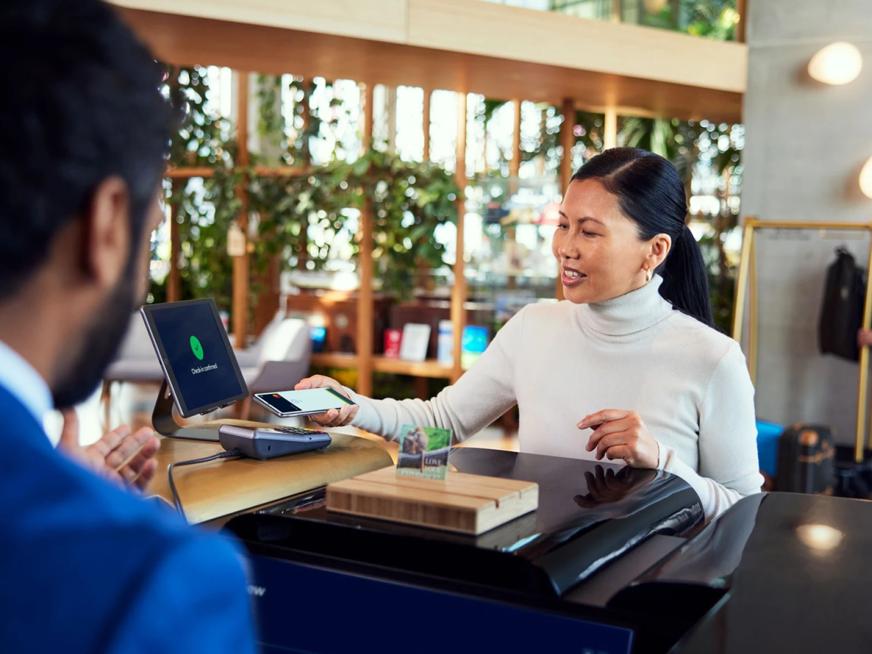 Woman paying with her phone at a hotel