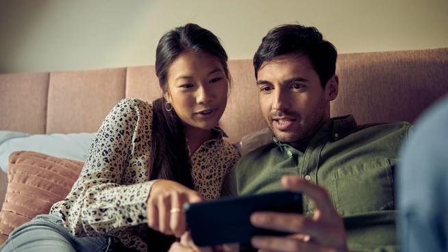 Eine Frau und ein Mann schauen auf ein Smartphone