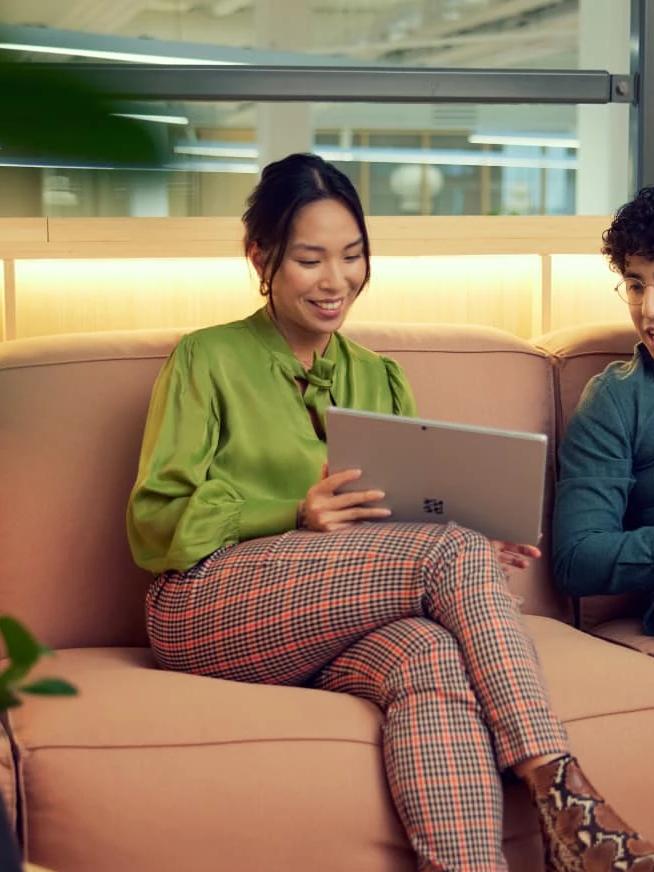 Zwei Personen schauen auf einen Laptop