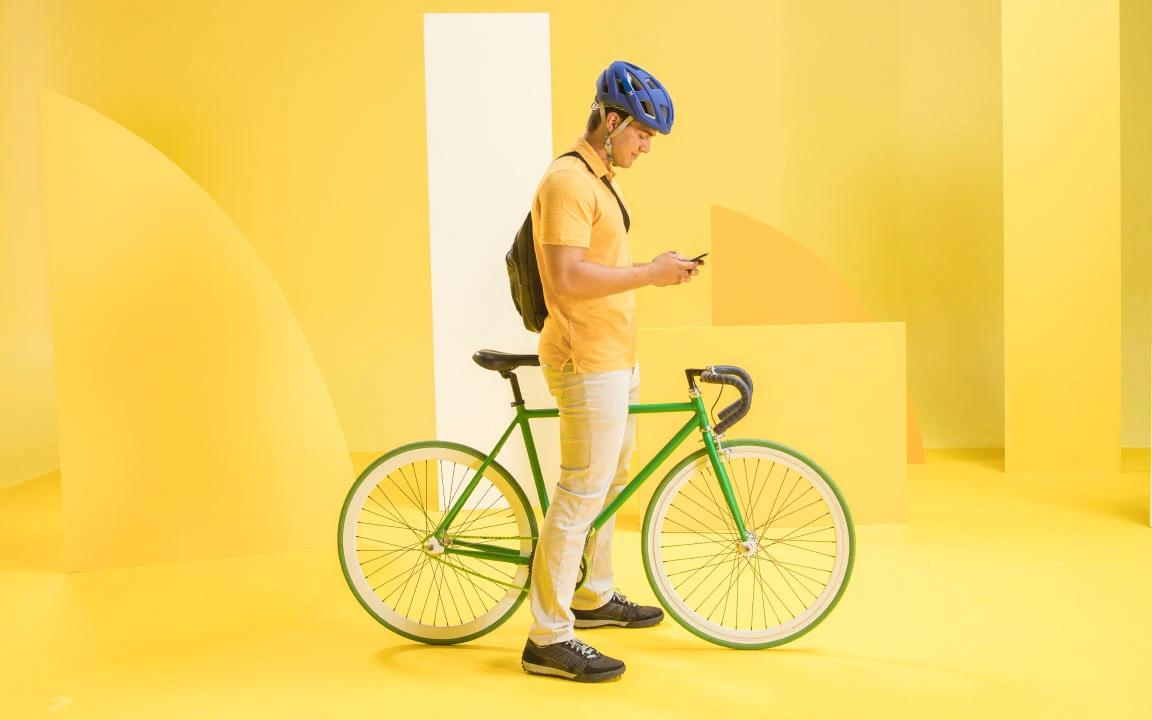 Man standing with bike looking at phone