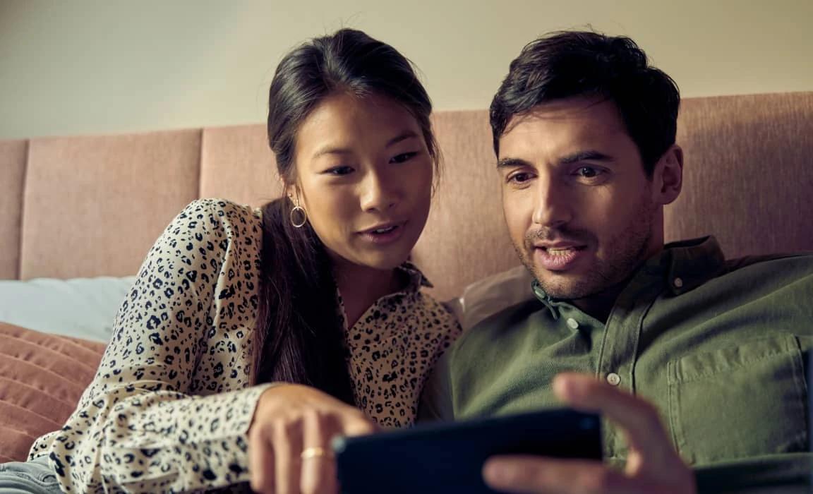 Una coppia che prenota un hotel tramite smartphone