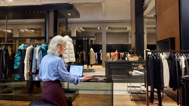 Woman on laptop in a luxury clothing store